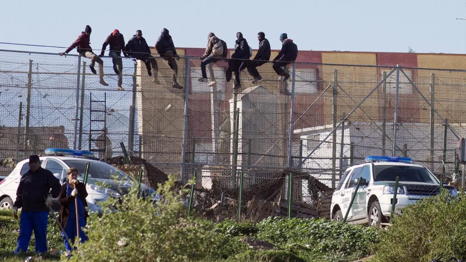 Un grupo de agentes intenta evitar el salto de la valla.