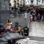 Refugiados afganos permanecen en un campamento improvisado en la plaza Victoria de Atenas