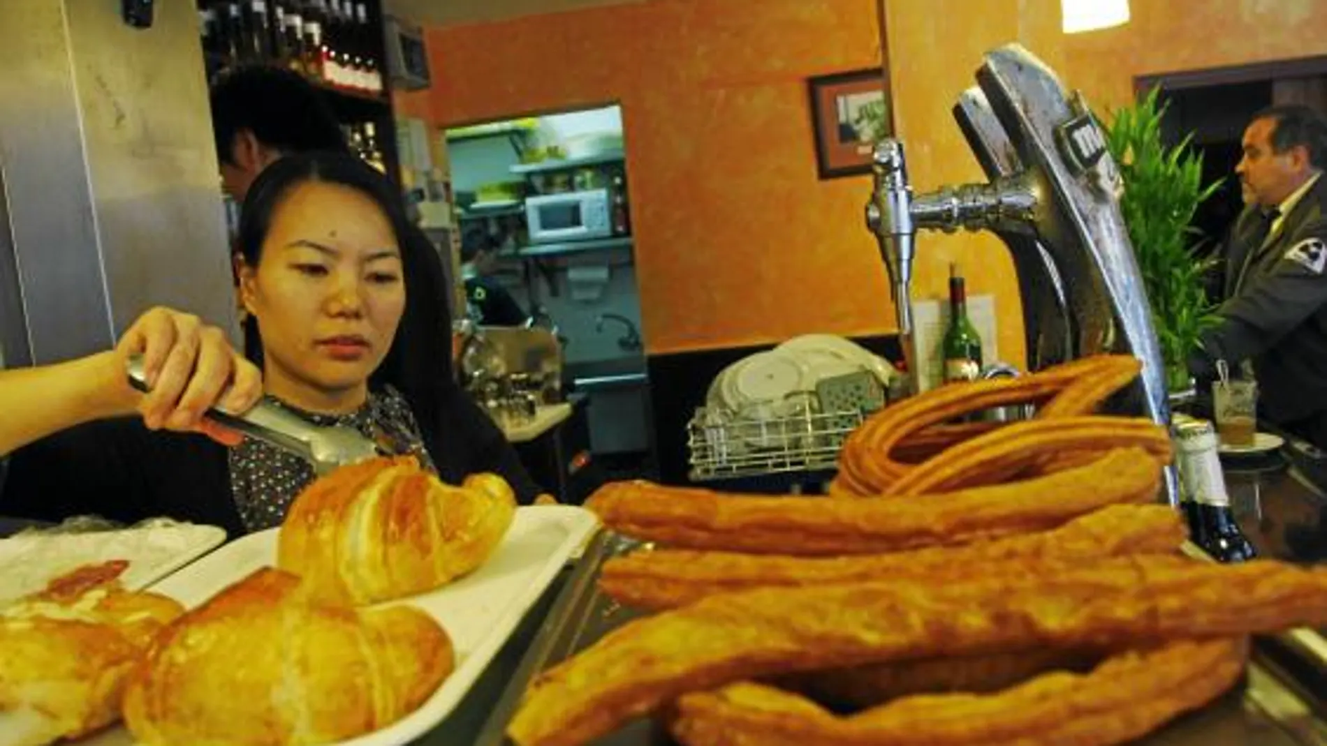 Una trabajadora extranjera atiende en un bar