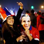 Unos aficionados chilenos, con un careta de Alexis Sánchez, celebran la victoria