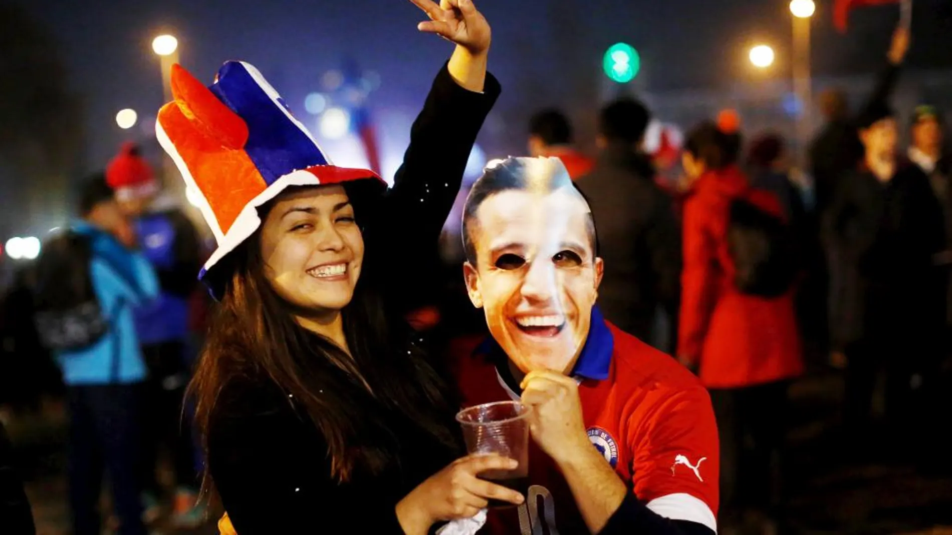 Unos aficionados chilenos, con un careta de Alexis Sánchez, celebran la victoria