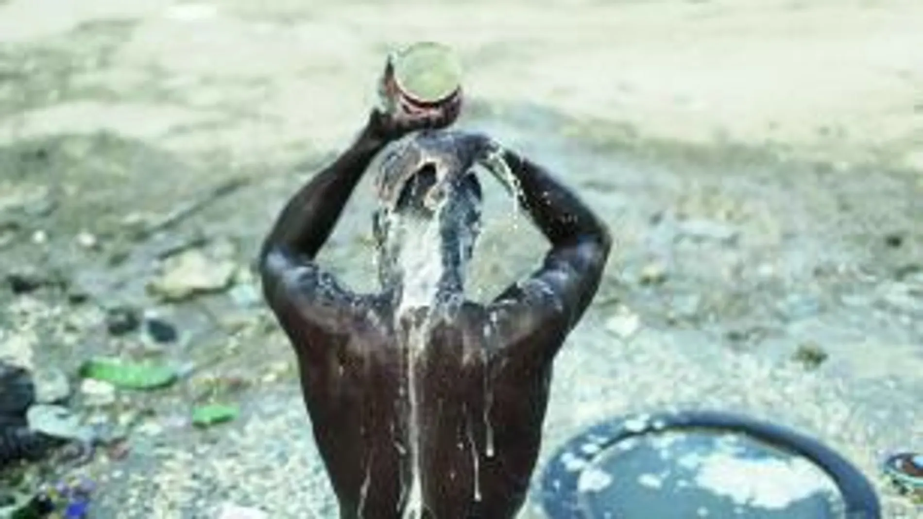 Sólo el 20 por ciento de la población haitiana tiene agua. En la imagen, un hombre se lava en la calle