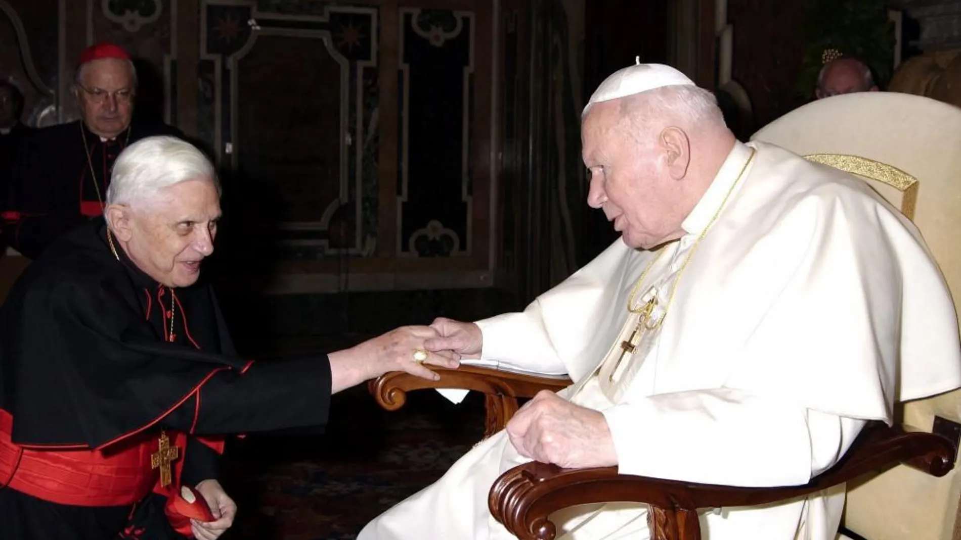 El entonces cardenal alemán Joseph Ratzinger saludando al papa Juan Pablo II durante una reunión con la Curia en el Vaticano en 2005
