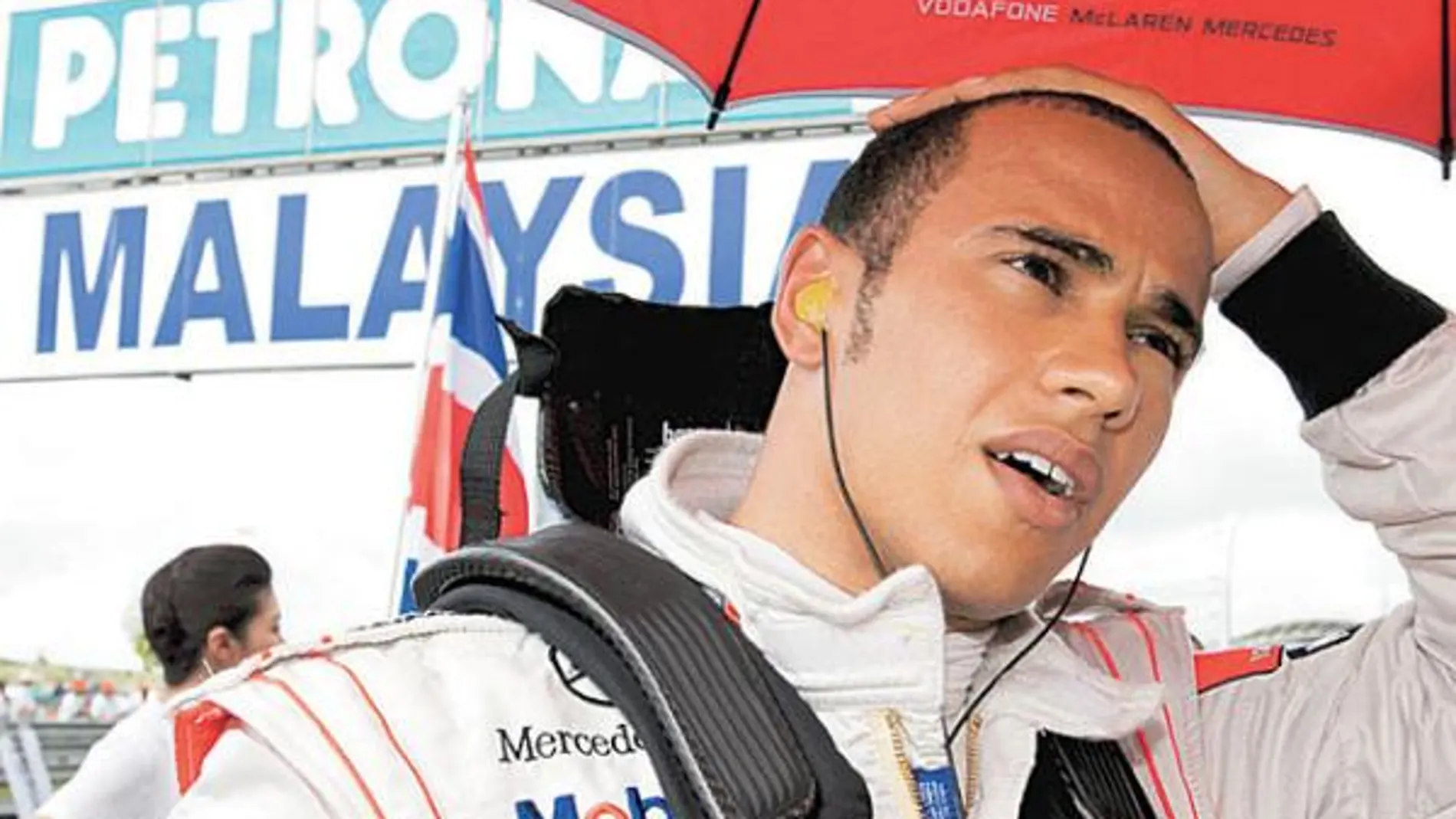 Lewis Hamilton se protege de la lluvia en el Gran Premio de Malasia