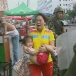 Una mujer huye con su hija de los disturbios del domingo