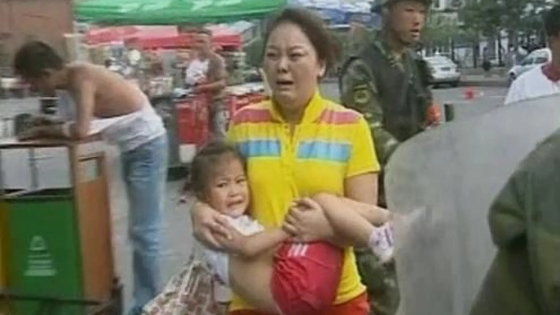 Una mujer huye con su hija de los disturbios del domingo