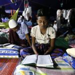 Musulmanes migrantes Rohingya leen el Corán durante el primer día del mes de ayuno de Ramadán en un campo de refugiados en Bireun Bayeun (Indonesia).