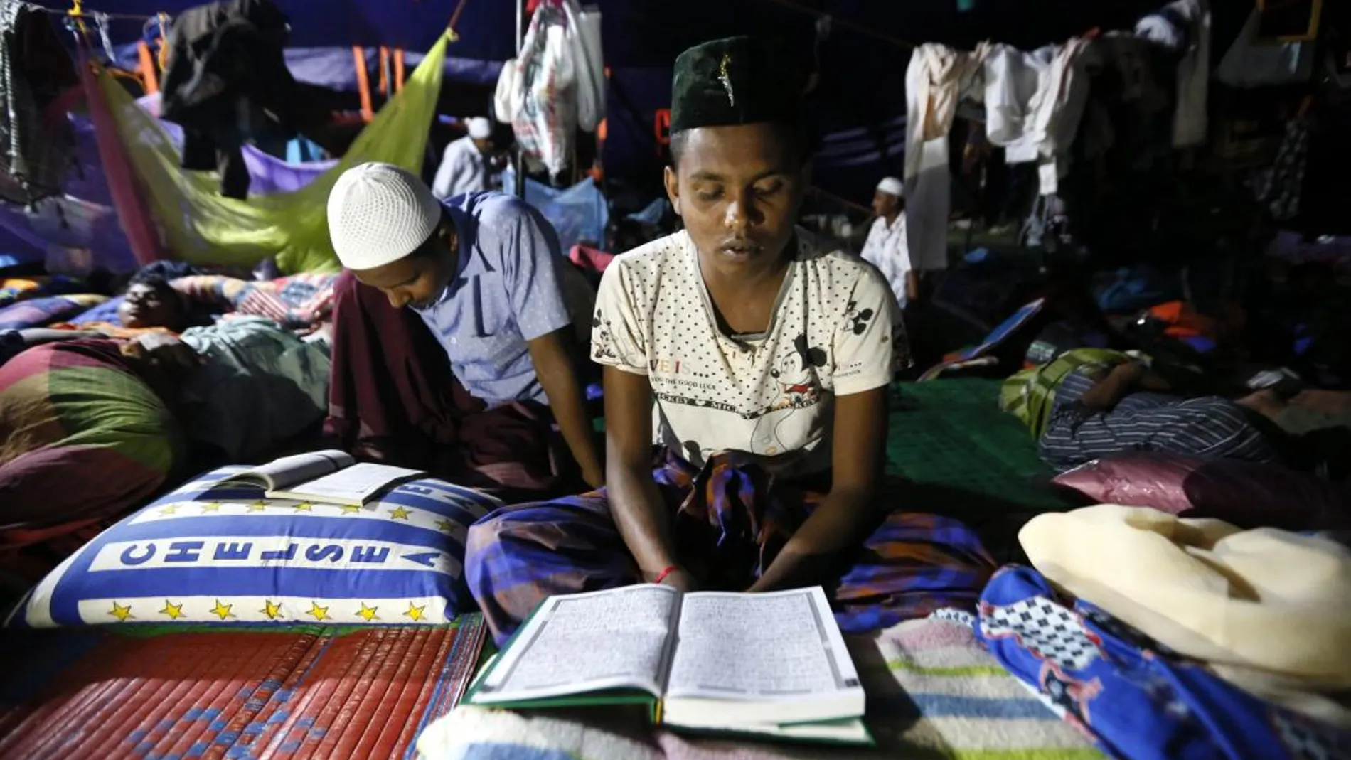 Musulmanes migrantes Rohingya leen el Corán durante el primer día del mes de ayuno de Ramadán en un campo de refugiados en Bireun Bayeun (Indonesia).