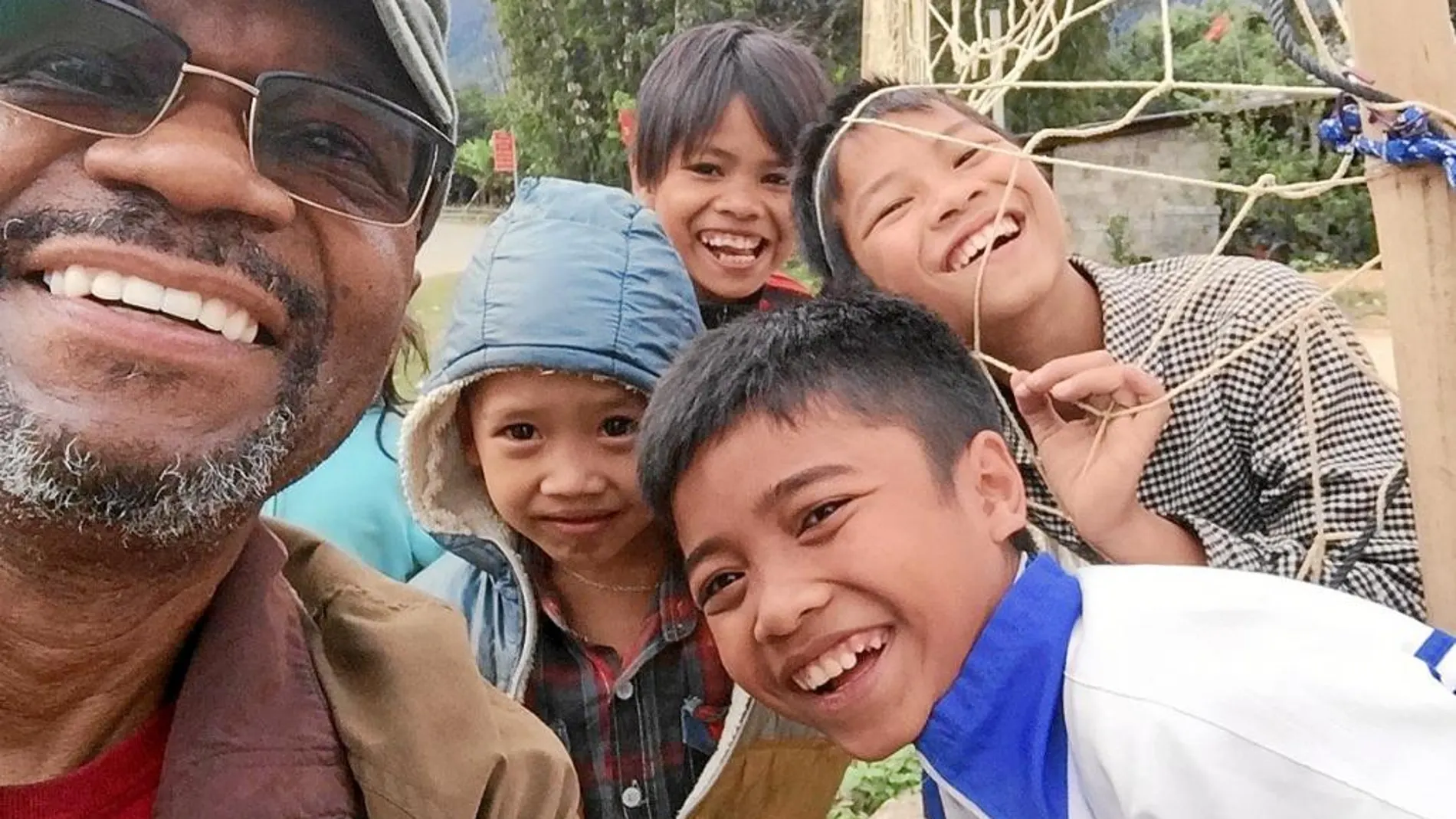 Proctor con unos niños vietnamitas durante su vuelta a unas tierras que pisó hace cuarenta años de una manera muy diferente
