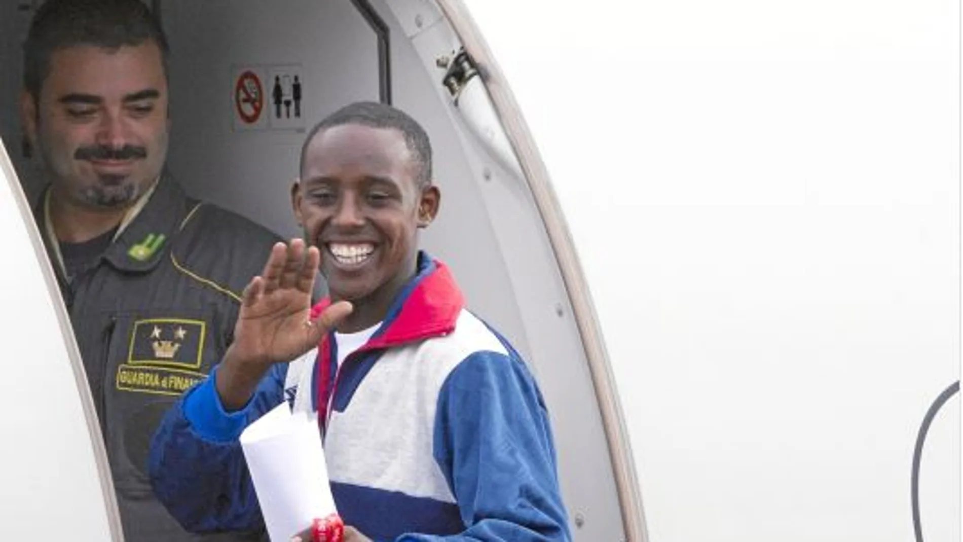 Un eritreo se despide al subir al avión que le trasladará de Italia a Suecia