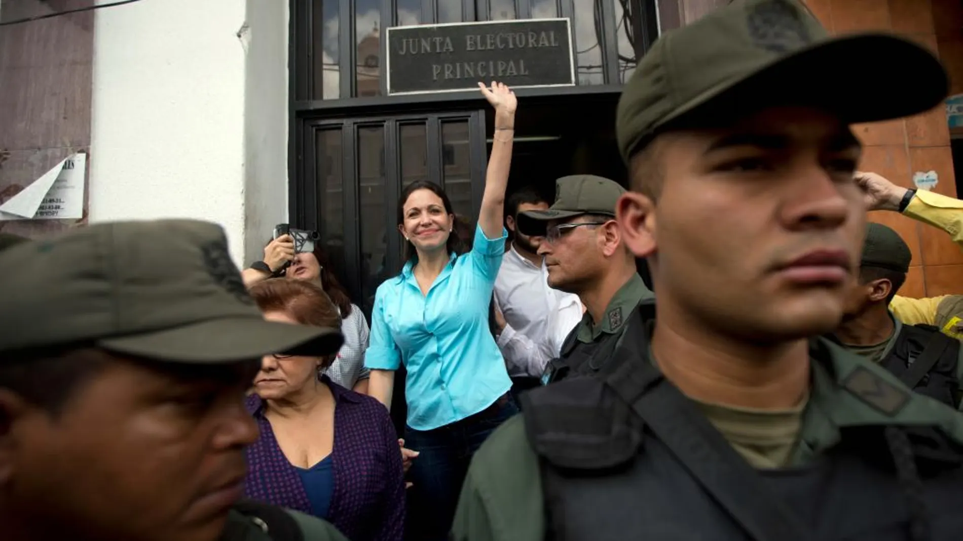 La exdiputada venezolana de la Asamblea Nacional (AN) María Corina Machado (c) sale de la sede de la Junta Electoral Principal