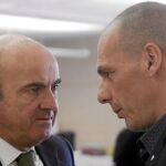 El ministro de Economía, Luis de Guindos, conversa con su homólogo Yanis Varufakis en la reunión del Eurogrupo