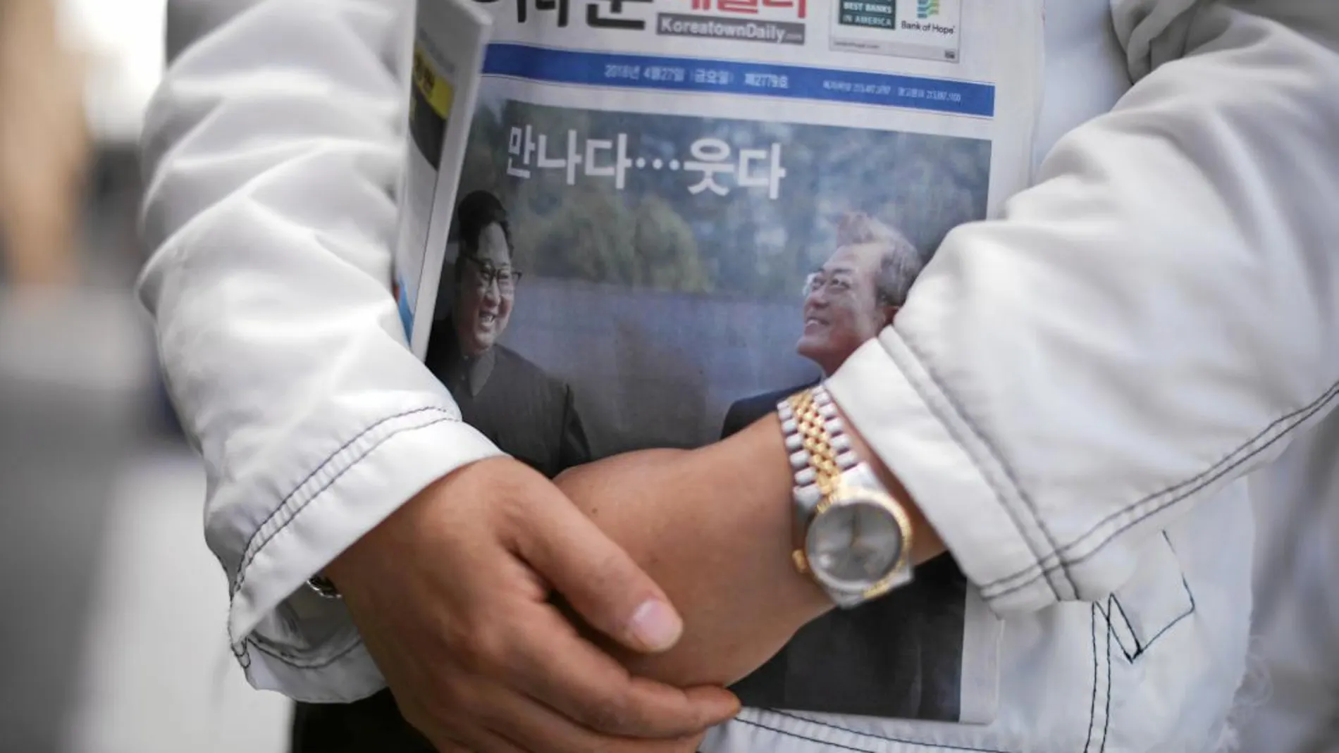 Ssoonie Kim, de 45 años, abraza un periódico con la portada dedicada a la histórica cumbre intercoreana del viernes