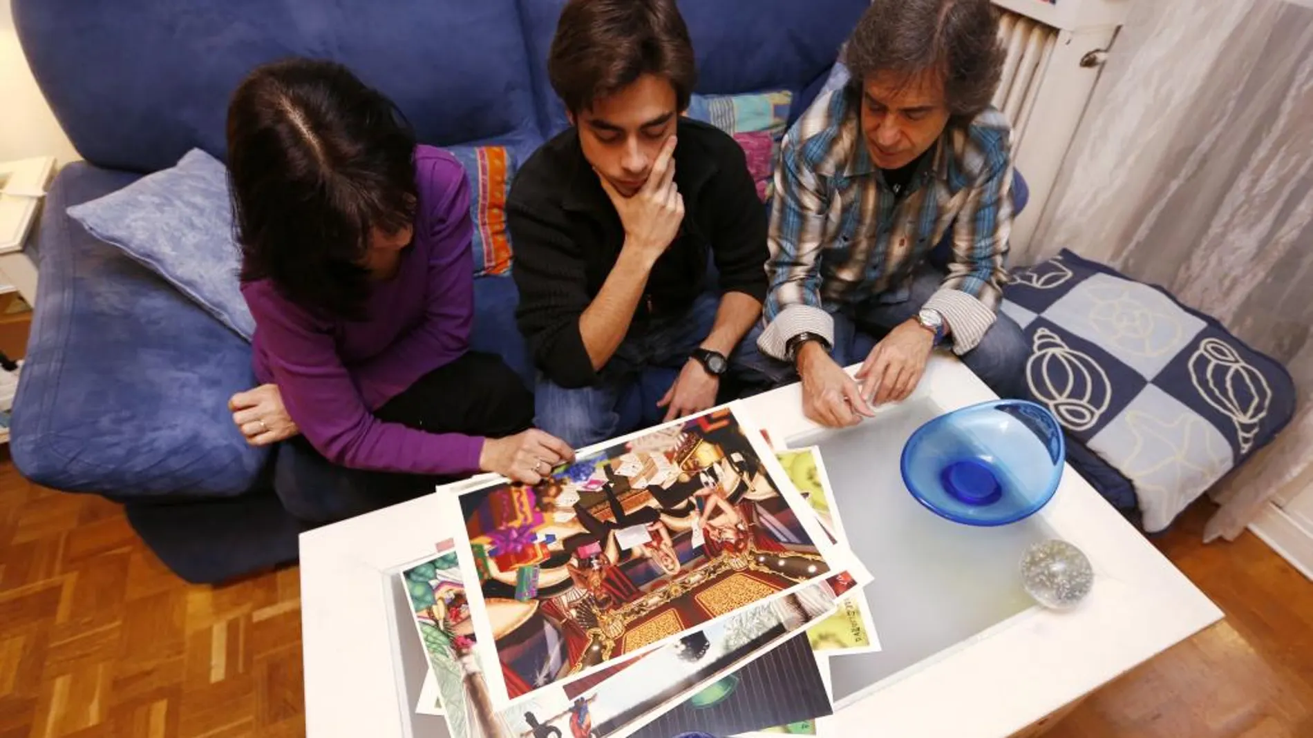 La familia del primer fallecido de 2015 y uno de los casos sin resolver, ayer, en su casa de Villaverde. Eva, Víctor y Jesús recuerdan las pinturas de Adrián, amante de las artes gráficas.