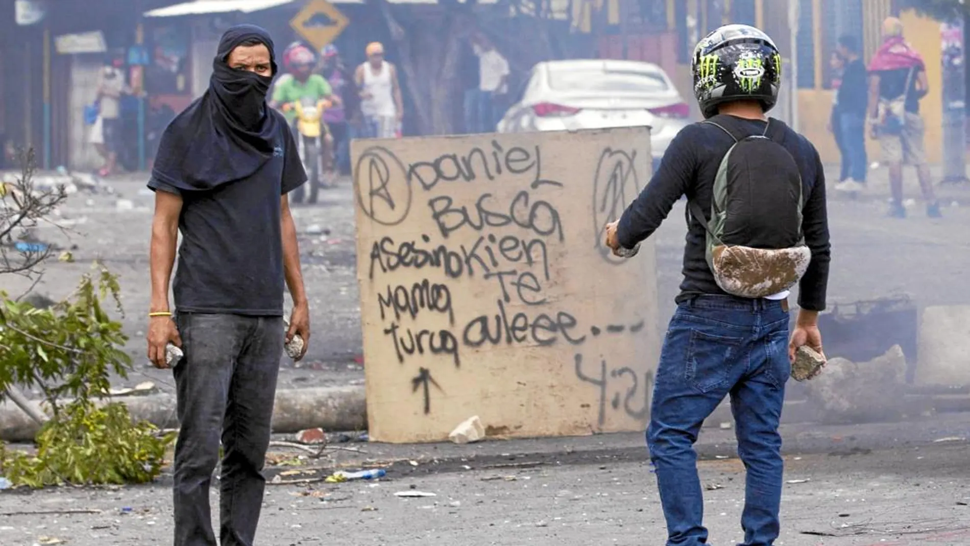 Dos jóvenes portan piedras en una barricada en los alrededores de la Universidad Politécnica de Nicaragua (UPOLI)