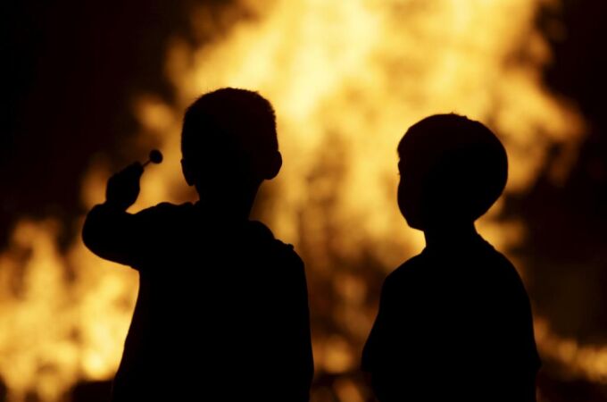 En la imagen, dos niños frente a las hogueras de las fiestas de San Juan | Imagen de archivo