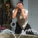 Un hombre intenta refrescarse en una fuente de Córdoba / Efe
