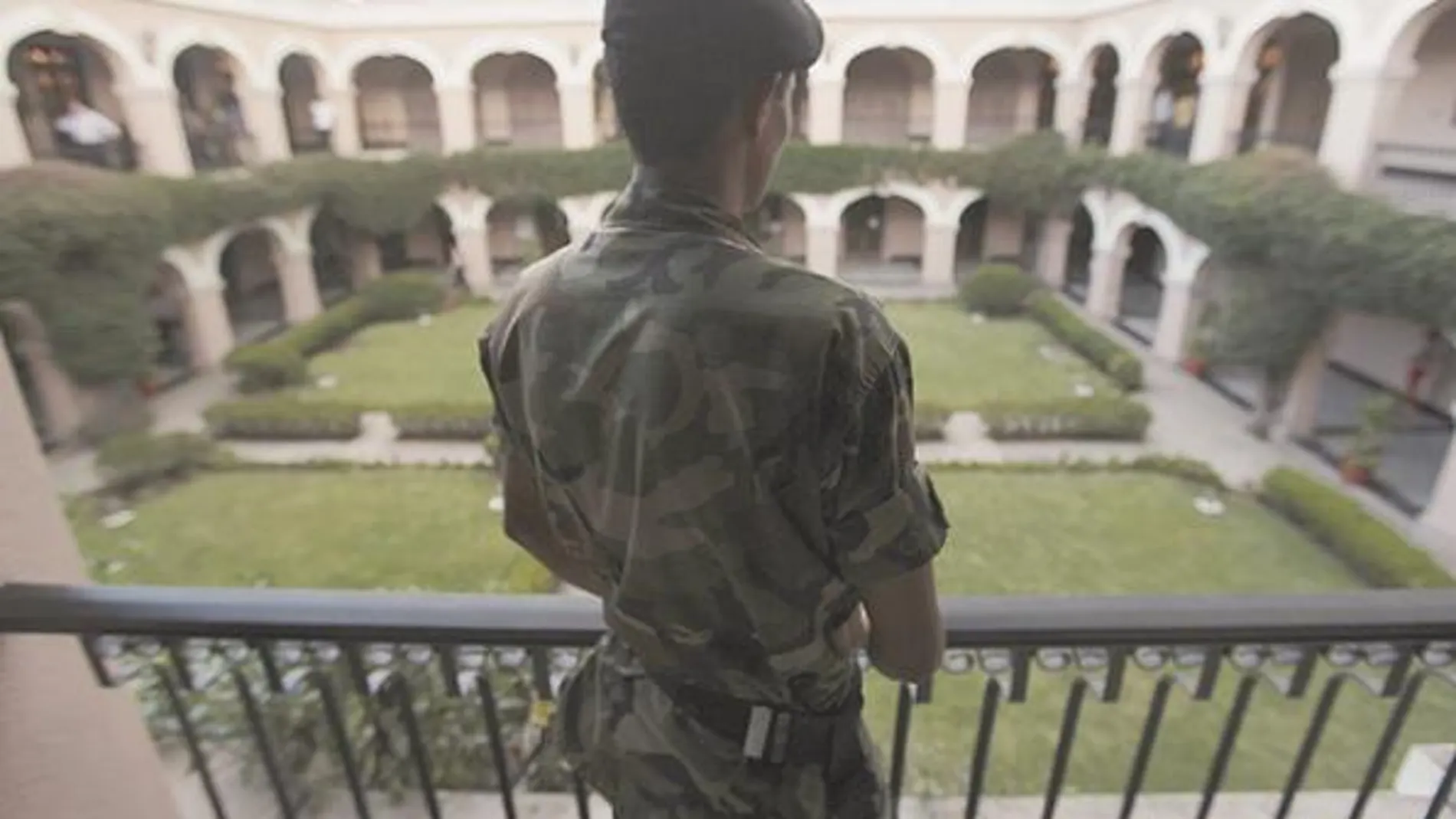 Un soldado vigila la residencia presidencial en Tegucigalpa ante la posible llegada de Zelaya a Honduras