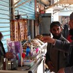 Miembros del Estado Islámico hablan con un vendedor en una calle de Raqqa, Siria