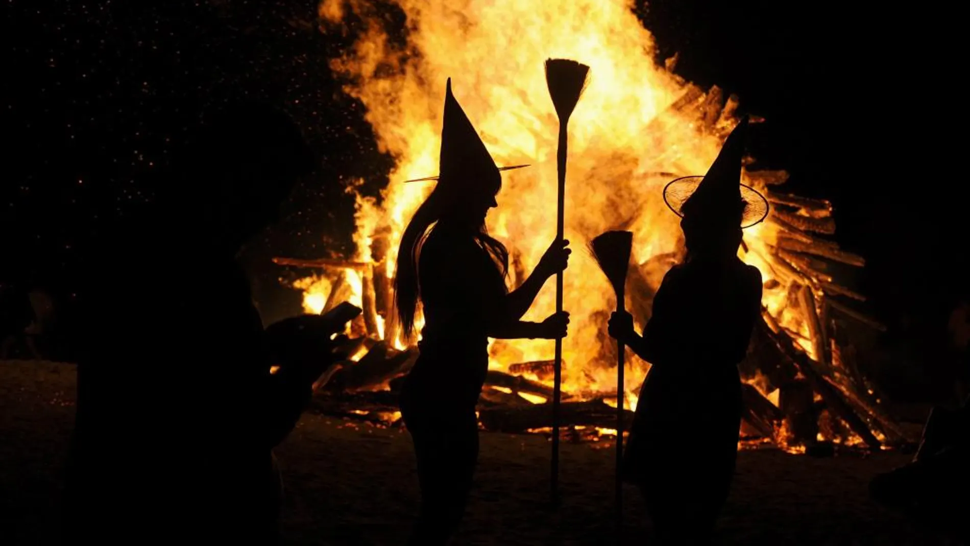 Dos mujeres vestidas de brujas durante la noche de San Juan en Gijón