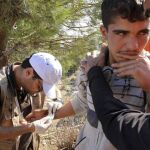 Un médico voluntario de la ONG "Doctores Voluntarios - Chipre"examina a un joven en un campamento para refugiados en la localidad de Mersinidi, isla de Chios