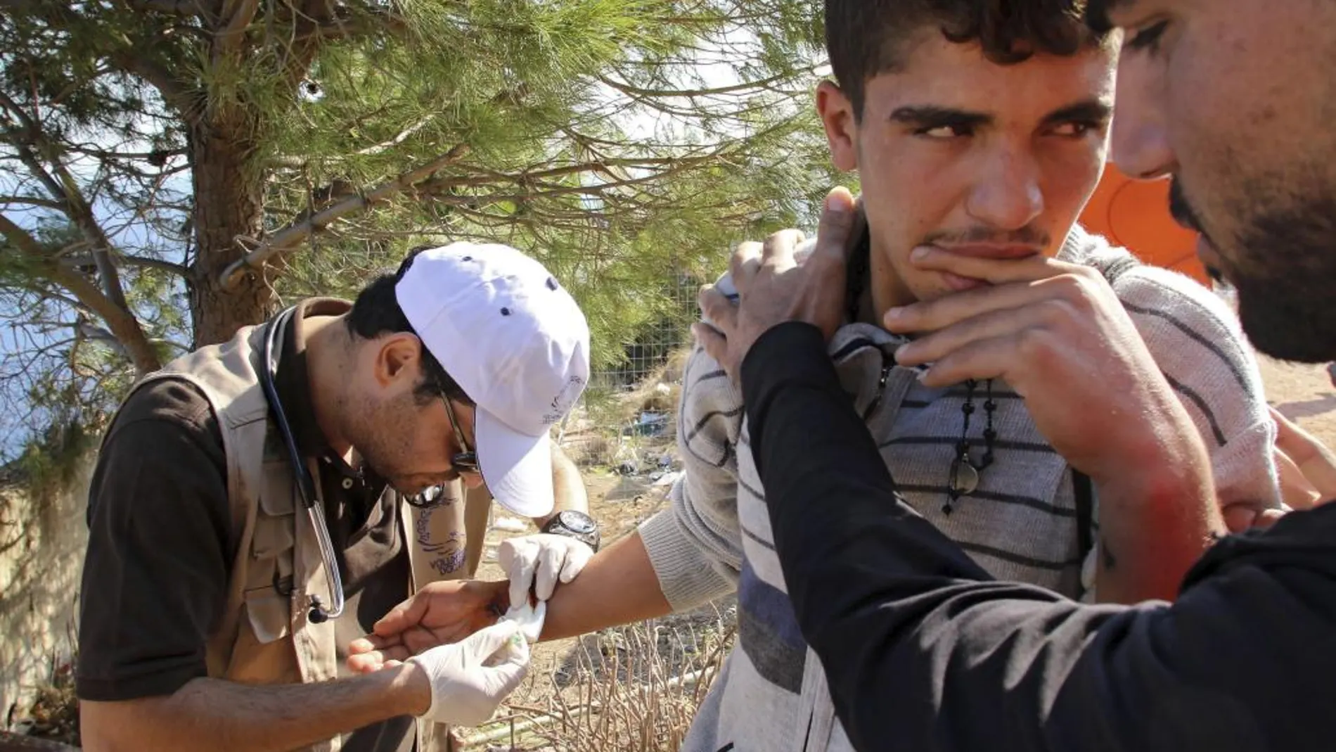 Un médico voluntario de la ONG "Doctores Voluntarios - Chipre"examina a un joven en un campamento para refugiados en la localidad de Mersinidi, isla de Chios