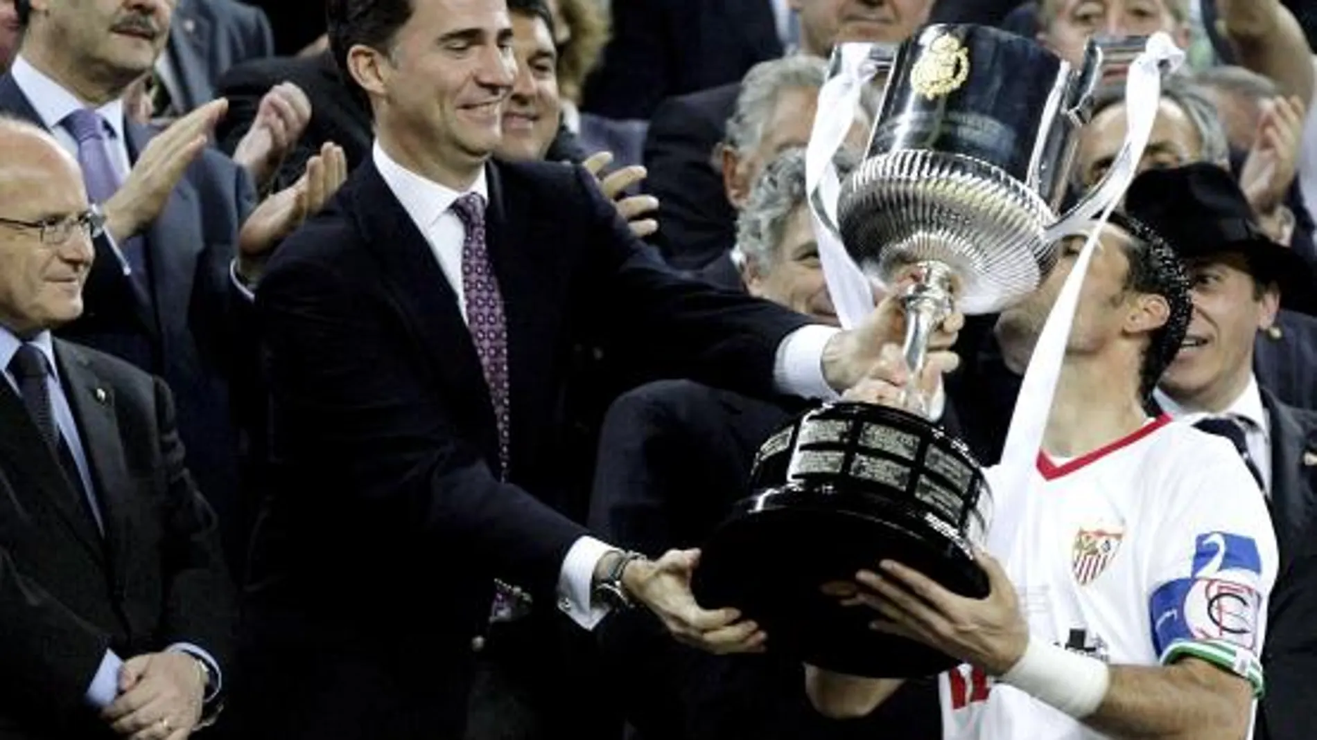 El capitán del Sevilla Palop (d) recibe el trofeo de manos del Príncipe Felipe, tras imponerse en la final de la Copa del Rey al Atlético de Madrid en partido disputado esta noche en el Camp Nou, en Barcelona