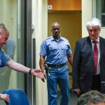 El exlíder serbobosnio Radovan Karadzic (dcha) a su llegada a la sala del tribunal del Mecanismo para los Tribunales Penales Internacionales (MICT) para el inicio del examen de su recurso de apelación en La Haya (Holanda) hoy