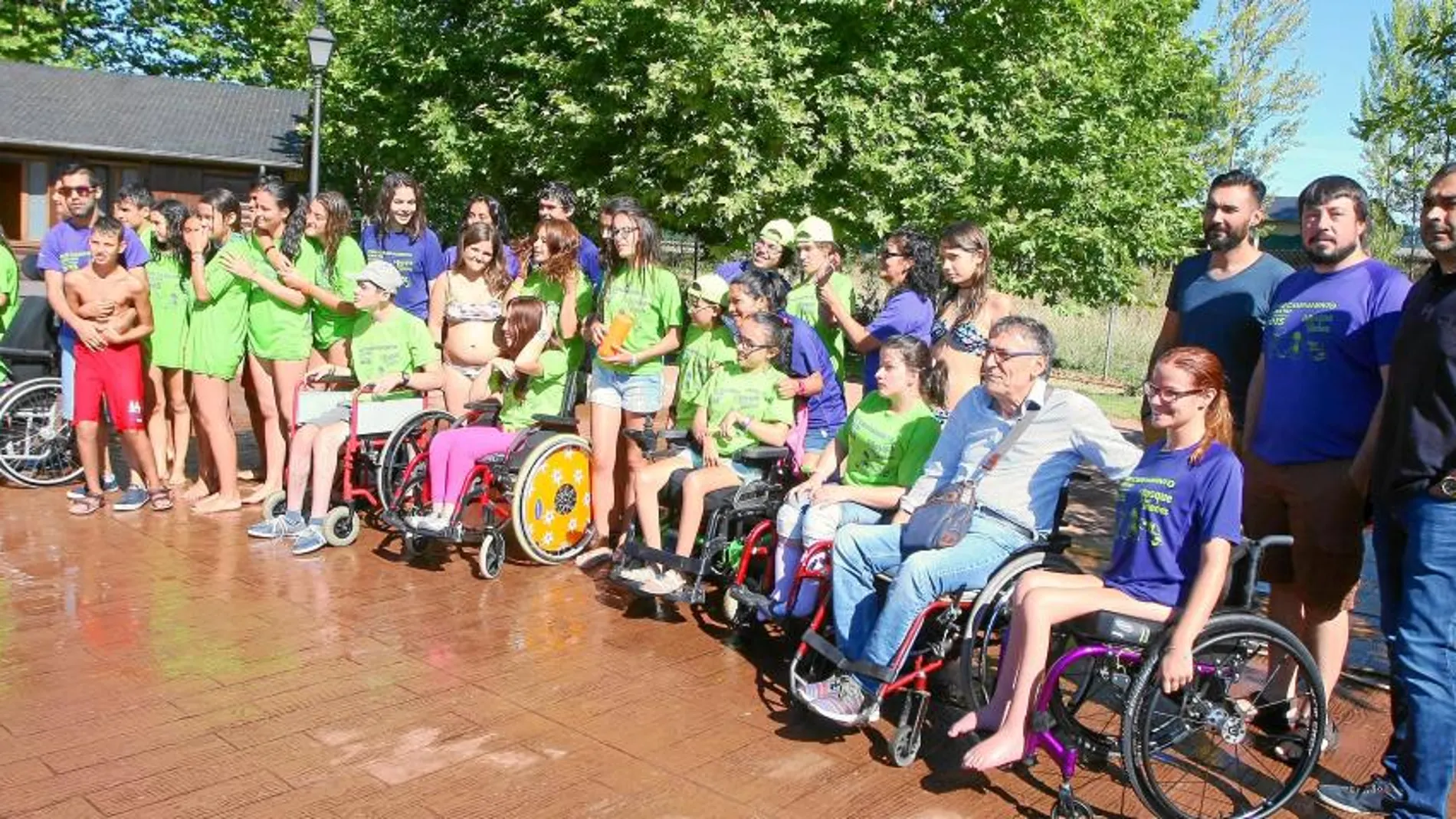 Foto de familia de autoridades y representantes de Aspaym con los niños que participan en la XVIII edición del campamento Aspaym de Cubillos del Sil (León)