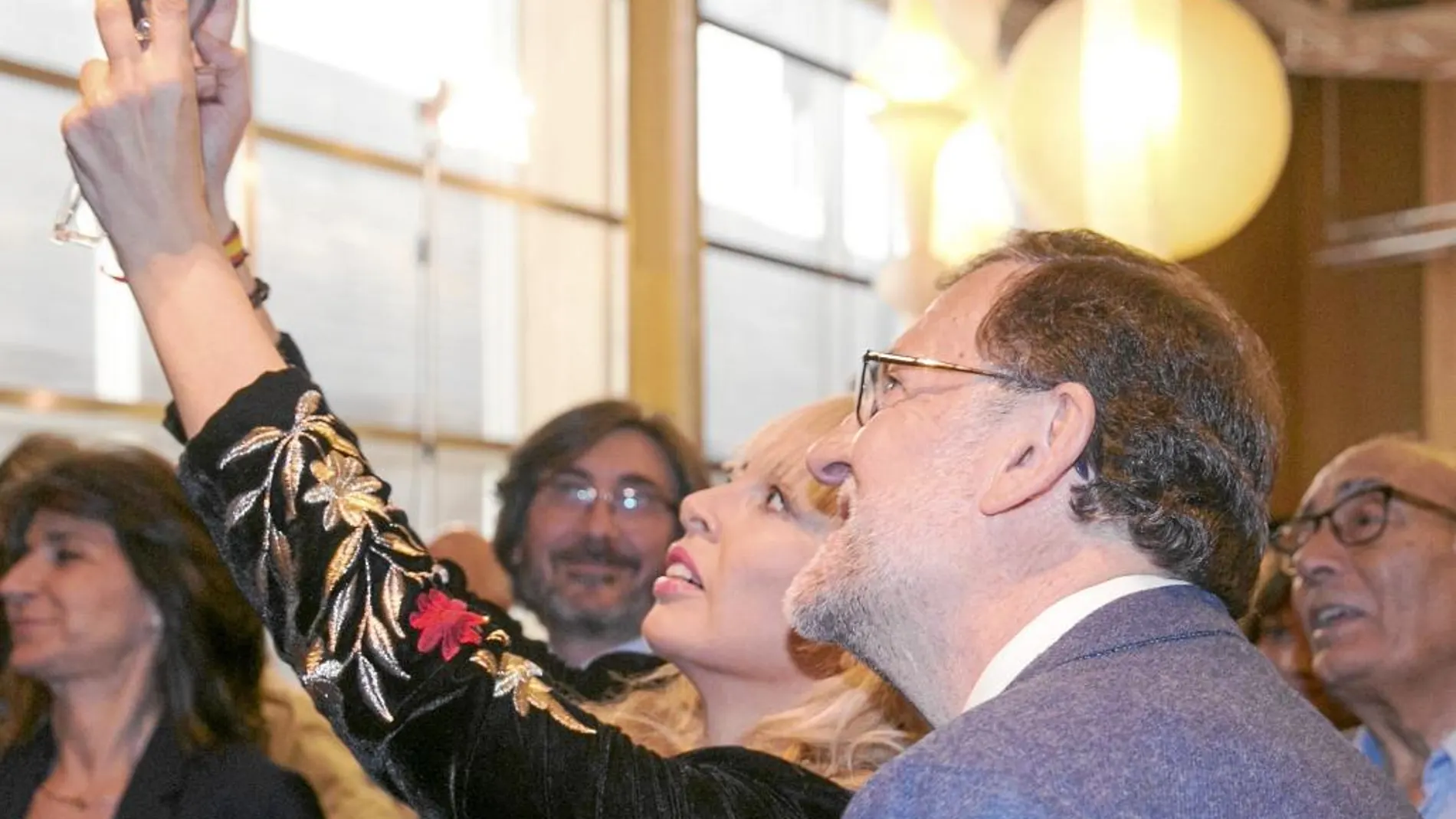 Rajoy se fotografía con una simpatizante del PP, ayer, tras la presentación de los candidatos de la coalición PP-PAR en Zaragoza