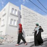 Mujeres palestinas frente a un muro temporal de hormigón en el barrio de Yabel Mukaber, en Jerusalén Este