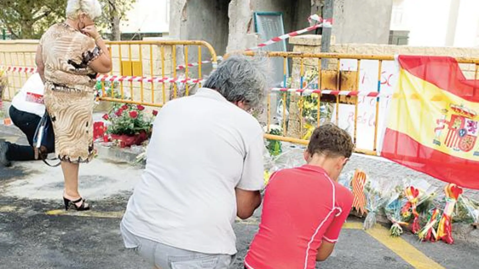 Un padre y su hijo rezan ayer en Calviá por los dos guardias civiles asesinados el jueves