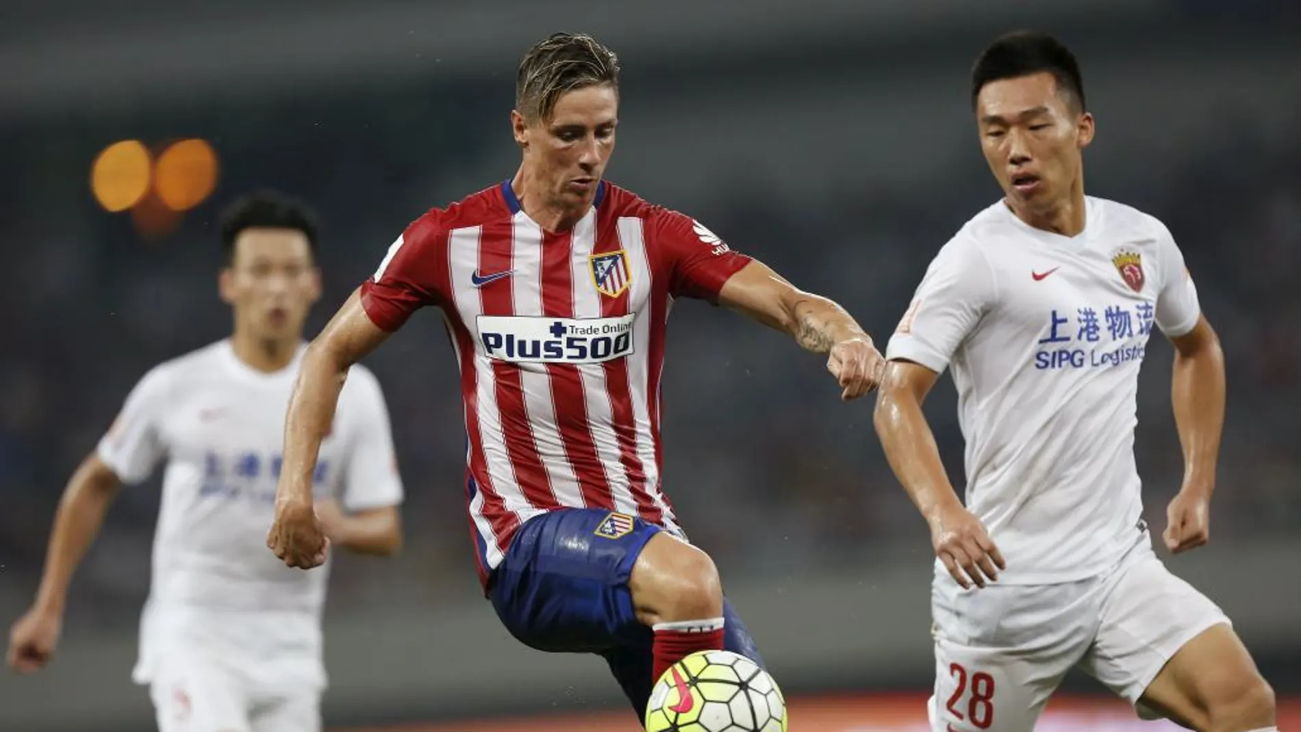 Fernando Torres quita un balón He Guan durante el amistoso