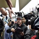 El piloto español de Fórmula Uno Fernando Alonso reparte autógrafos a sus fans en el circuito de Suzuka en Japón