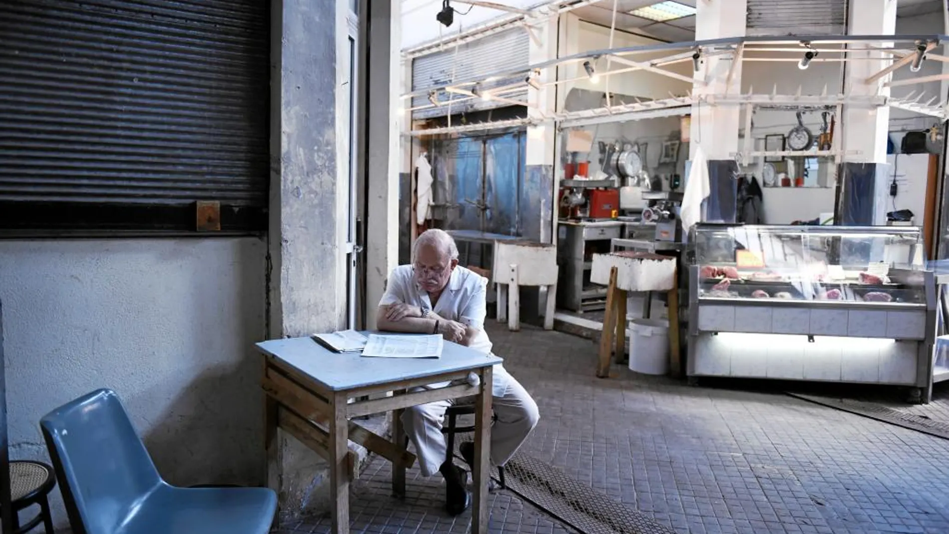 Un ateniense ojea el periódico en un desabastecido mercado de la capital helena
