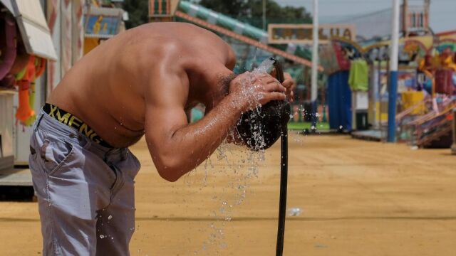 Un hombre se refresca en el recinto ferial de Huelva, donde hoy se han registrado 45 grados de máxima. /Foto: Efe