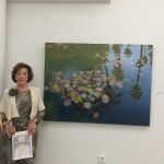 La pintora Irene Iribarren, posando junto a su obra premiada «Estanque de nenúfares en Marraquech» luciendo el Diploma acreditativo