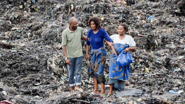 Varias personas observan las labores de búsqueda de los servicios de emergencia en un basurero de Maputo (Mozambique)