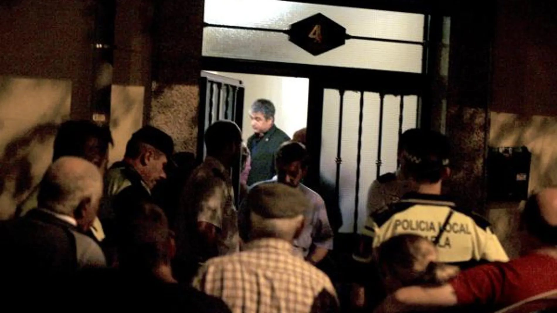 Efectivos de la policía esperan junto a familiares y amigos a la retirada de los cuerpos