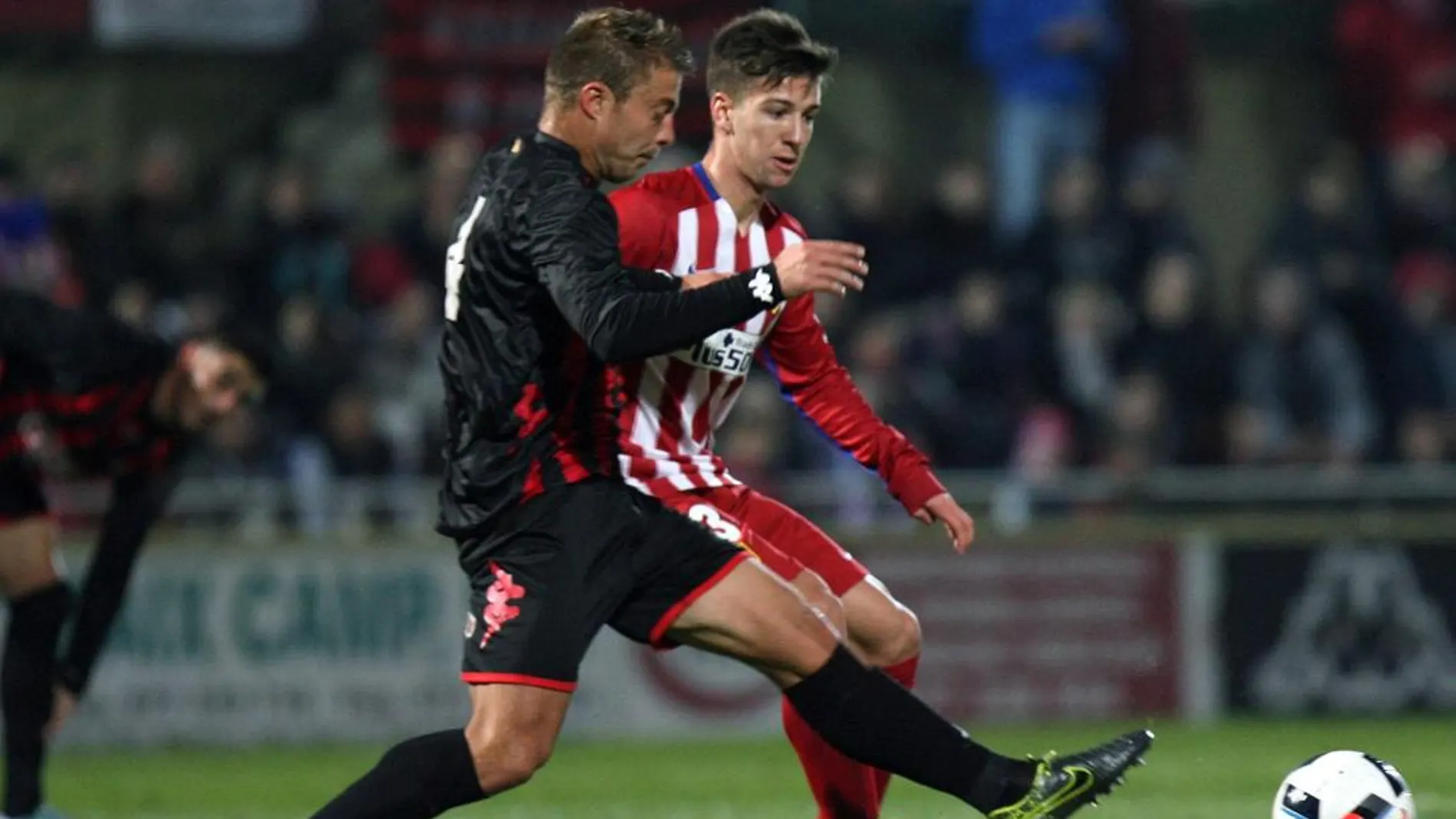 El delantero argentino del Atlético de Madrid Luciano Vietto (d) lucha el balón con Jesús Olmo, del Reus