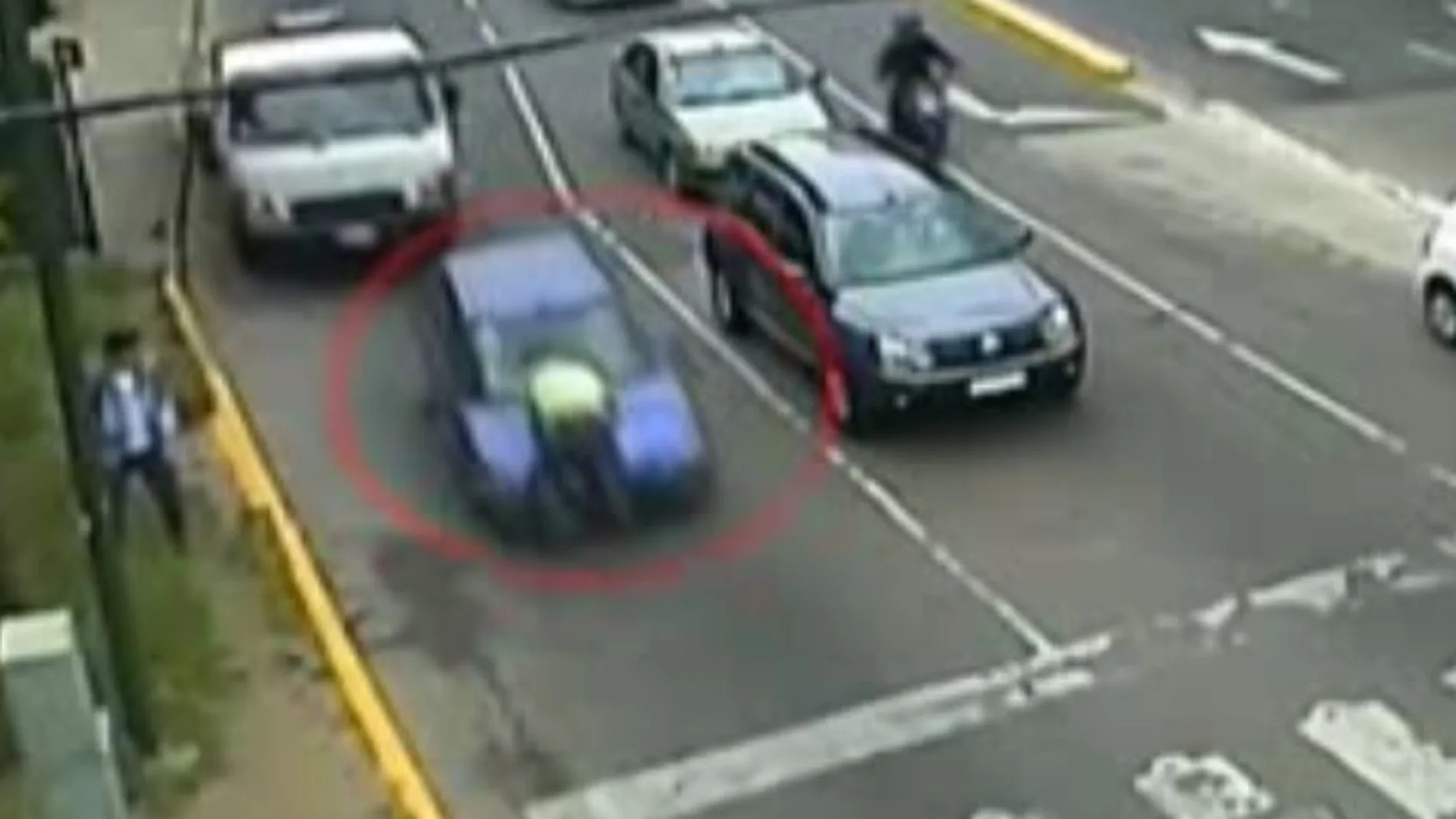El agente de policía sobre bel capó del coche tras ser embestido y arrastrado