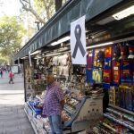 Un lazo negro cuelga de uno de los kioskos de las Ramblas de Barcelona tras el atentado del pasado verano