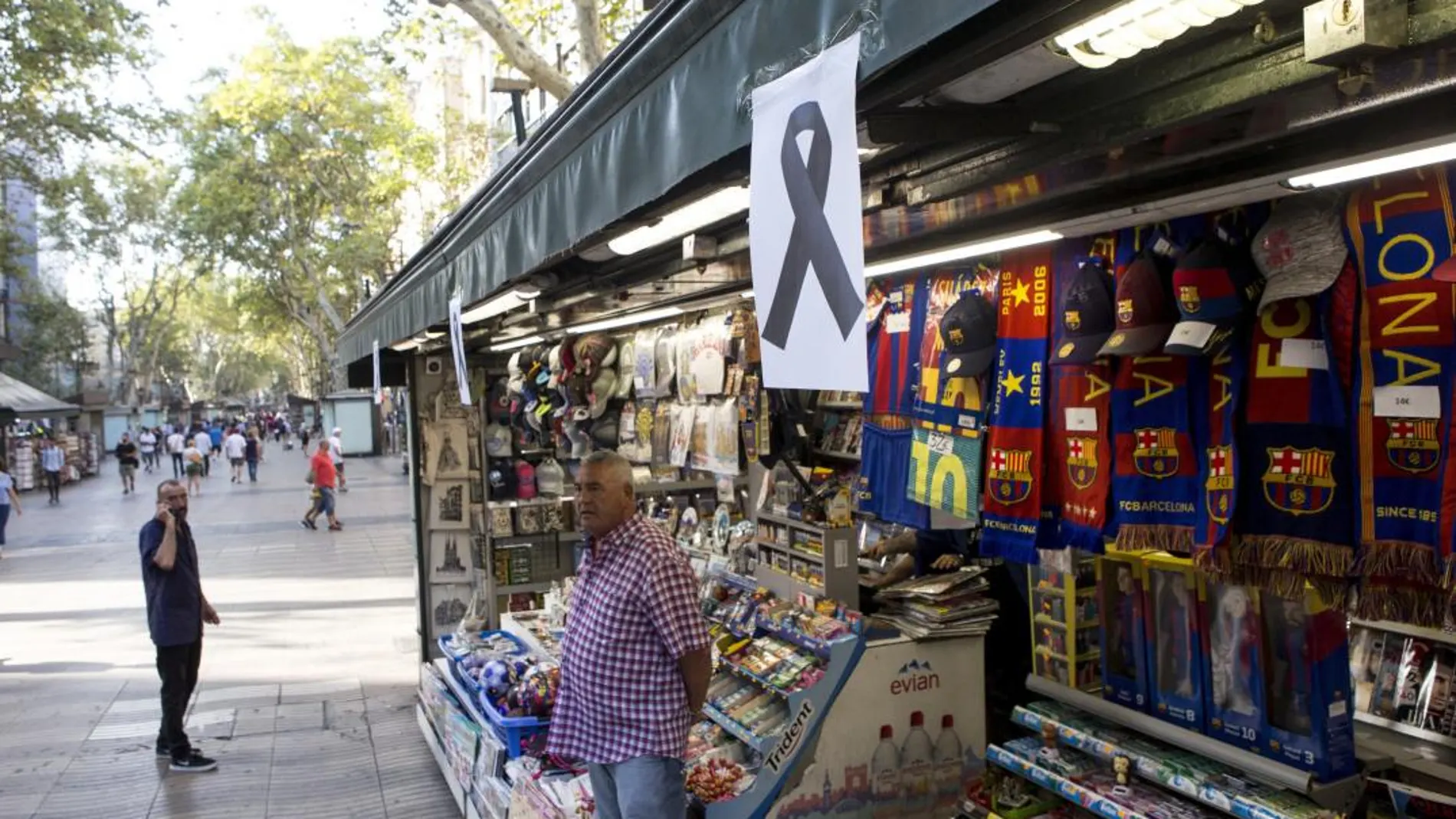 Un lazo negro cuelga de uno de los kioskos de las Ramblas de Barcelona tras el atentado del pasado verano
