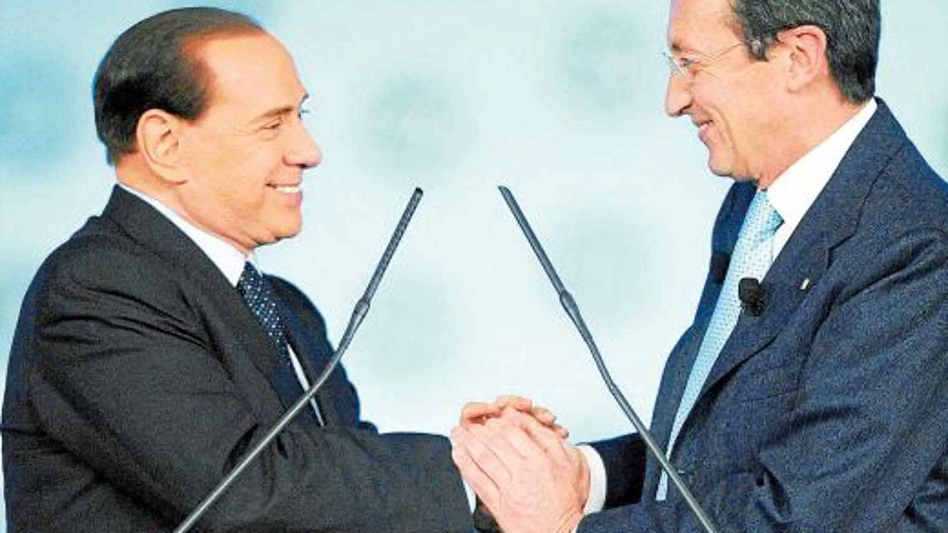 Berlusconi y Fini se dan las manos durante la segunda jornada del congreso del PdL, ayer en Roma