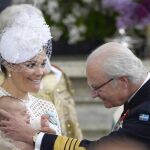El rey de Suecia acaricia a su nieto Óscar, hijo de Victoria