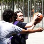 El candidato de Unidos Podemos a la Presidencia del Gobierno, Pablo Iglesias (d), juega un partido de baloncesto en la Ciudad Universitaria de Madrid