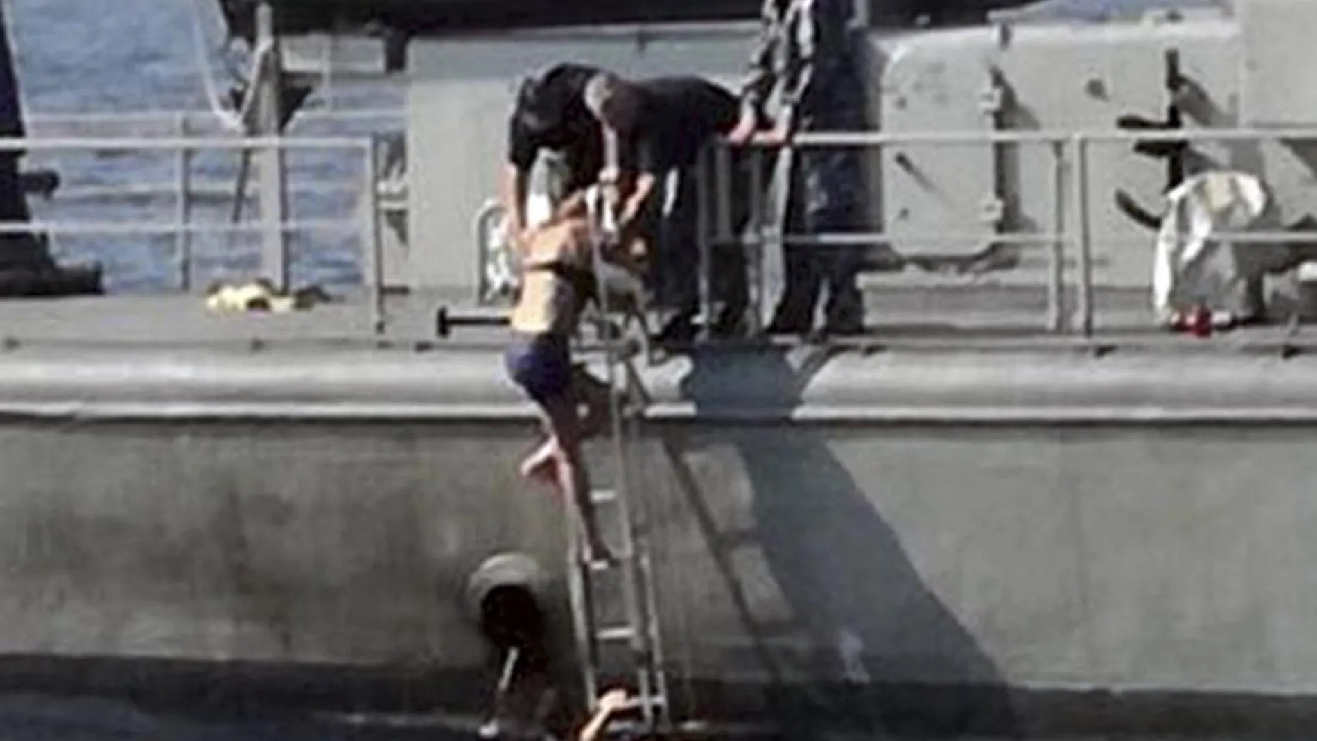 La mujer en el momento de subir al barco que la rescató/Ap