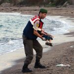 Un oficial de la policía paramilitar lleva el cuerpo sin vida de Aylan Kurdi
