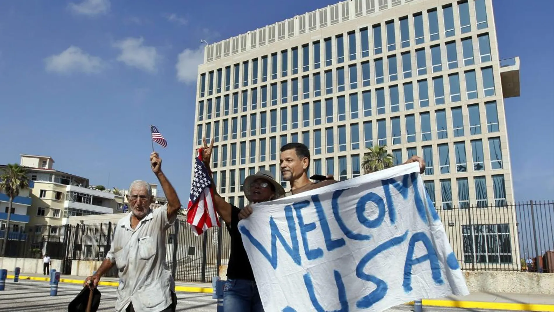 Un grupo de personas sostiene una pancarta y agita banderas frente a la embajada de Estados Unidos en La Habana (Cuba). Lunes 20 de julio del 2015.