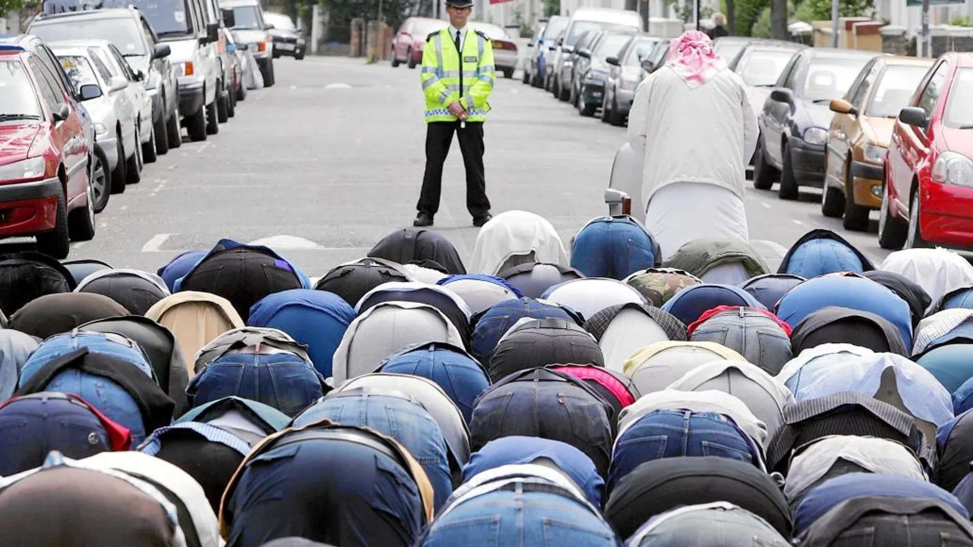Un grupo de musulmanes reza en una calle de Londres ante la antenta mirada de un policía